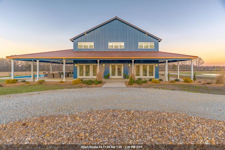 Welcome to Market 4687 Hwy 141 N in Jonesboro, AR within the Jonesboro School District. Situated on 15.2 ± acres just outside city limits, this 2023 built, 2-story barndominium offers 3,280 sf of living space and a rare combination of gated entrance, circle drive, beautiful landscaping, 9 ± fenced acres, stocked pond, and saltwater inground pool creating an outdoor retreat w/ stunning sunset views. The main level showcases an open kitchen, dining, and living area highlighted by soaring 18-foot ceilings, oversized island, custom cabinetry, and a cozy gas log fireplace. The primary suite is on the main and offers a spa-inspired bath featuring a soaking tub, tiled shower, and dual vanity, along with a walk-in closet. An additional bedroom and full bath are on the main, while the upper level offers 2 bedrooms and a full bath. Step outside to a covered wraparound porch designed for gathering and relaxing. Additional features include an attached 1,200 sf garage/shop w/ mezzanine loft, detached carport, Empower fiber internet, and energy-efficient construction. Additional acreage available. Enjoy the peace of country living w/ the convenience of town nearby. Call today to make it yours.