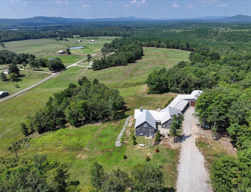 Custom-Built Home on 23± Acres | Lake Hamilton School District | RV Garage & Workshop  Spectacular custom-built home situated on approximately 23 acres in the Lake Hamilton School District, offering expansive views and memorable sunsets from the deck and stone patio. This well-built 4-bedroom, 4.5-bath residence features vaulted ceilings, thoughtful design, and construction focused on durability, comfort, and security.  Built with 12-inch concrete walls, the home includes two primary suites on the main level, two laundry rooms, and a dedicated safe room. The open layout provides generous living space, complemented by a large game room ideal for entertaining or recreation.  Garage and workspace features include a 3-car garage, a separate RV garage, totaling approximately 2,761 square feet of garage space, plus an 894 sq. ft. heated and cooled workshop. A whole-house generator adds reliability and peace of mind.  Privately located yet conveniently positioned approximately 30 minutes from Oaklawn Racing & Casino and Lake Ouachita, this acreage property offers space, functionality, and flexibility for a variety of uses.  A rare opportunity to own a custom home on acreage