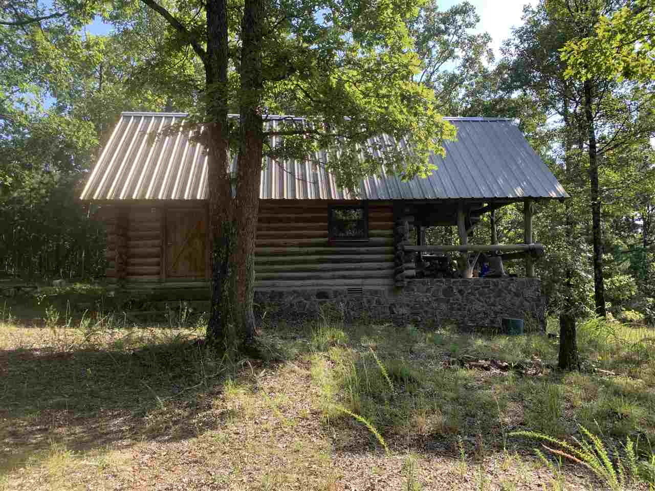 Here is a rare find in the Ozarks, good timber with deeded access from several points around the property. White Oaks, a few pine, Cedar, flagstone, ornamental boulders, Two good creeks, amazing trail system, John Deere 650 model bulldozer that runs very well for trail maintenance, and primitive 1bedroom Log Cabin!!! This property has lake access to Greers Ferry using Wild Goose Creek to access the lake. Mineral Rights do not convey with property. Outstanding timber Track for investing and surface rock.