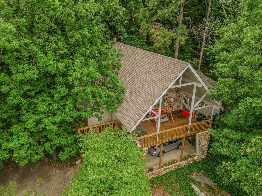 VIEW OF GREERS FERRY LAKE & SUGARLOAF ISLAND  are enjoyed from this unique home.  You'll enjoy hours out on the expansive deck enjoying scenic sunsets, wildlife, and the natural surroundings.  Over 2500 sq. ft. offers a great room with woodburning fireplace, a wall of windows to capture the view, updated kitchen/dining areas.  Custom cabinets in kitchen, lots of counterspace, appliances included (refrig-freezer, NEW dishwasher, trash compactor, electric range & microwave oven).  Adjoining the kitchen is a sizable laundry room with pantry, cabinets, desk.  This level has a half bath, plus the Master suite.  The Master Bath was recently updated with step-in shower.  The 2 Guest BR and a Guest Ba are upstairs.  Need a game room or hobby room, den, or extra sleeping space?  The lower level has a large bonus room for these uses.  The flooring is oak hardwood, tile, vinyl, carpet.   The Roof was replaced in early 2024.  HVAC is "dual fuel" and maintained semiannually.    The new owner will have Member access to all Fairfield Bay Resort-owned amenities.  Seller would possibly need Delayed Possession.  Call to schedule your appointment to take a personal look!