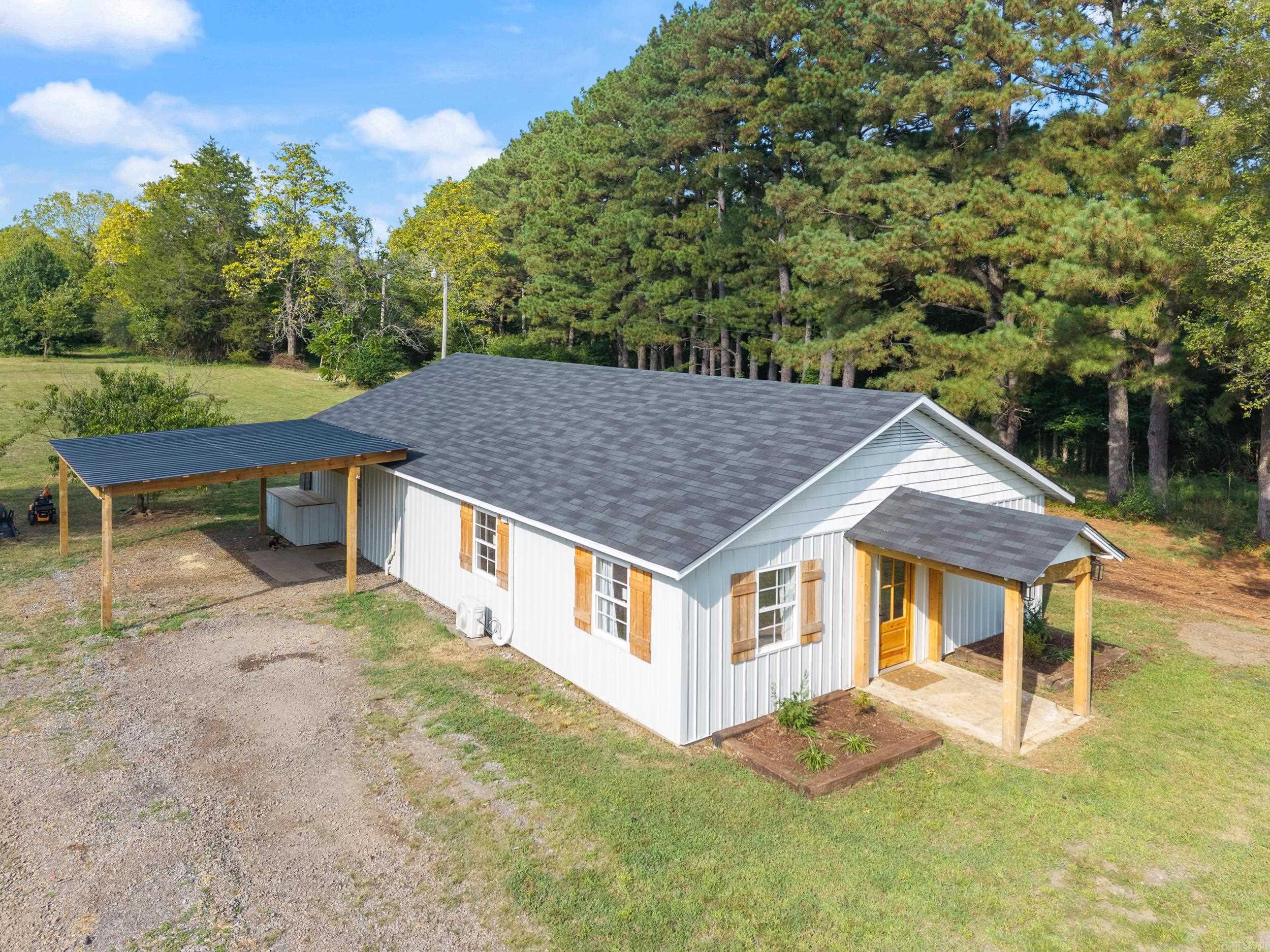 If you're looking for a place for you and a couple of horses, or if you simply like the privacy of the country life, then this property could be the one. This newly renovated farm home is situated on 5 acres bordered by trees, creating privacy between you and any neighbors. The property is just 8 minutes off Exit 129 in Conway and Hwy 286 E, making your commute to work a breeze. The home has a wonderfully wide-open floor plan with vaulted, wood ceilings from the front to the back of the home. The dining space offers seating for 16 around the built-in banquette and farm table with a unique handcrafted, live edge chandelier. Embrace the feeling of nature with the beautiful evergreen shaker cabinets and Hevea wood, butcher block countertops. All farmhouses need a least one barndoor and this barndoor conceals the pantry. Next to the pantry, there are 2 freezers, which are negotiable, for your farm-to-table foods. A large primary bedroom provides enough space for a nursery corner or office suite. Don't miss the white peach, plum and fig trees as you walk about the land. The home is on city water but there are two wells on the property that are not in use. Washer/Dryer are negotiable
