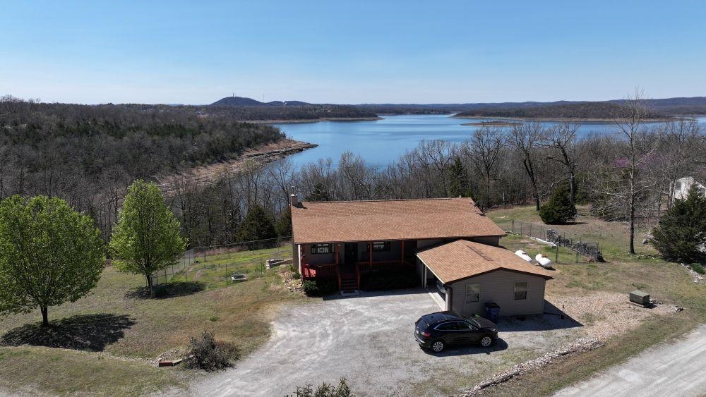 LOOKING FOR A HOME WITH A VIEW AND A BOAT SLIP? THIS IS IT! 2 BED, 2.5 BATH HOME BORDERING THE GOV’T CORPS, WITH A YEAR-ROUND VIEW OF BULL SHOALS LAKE AND A BOAT SLIP WITH LIFT. BUILT IN 2009, THIS HOME HAS CUSTOM HICKORY CABINETS, LAMINATE FLOORS, 36”- 6 PANEL WOOD DOORS, TILT WINDOWS, GUTTERS, ATTIC FAN AND A WHOLE HOUSE GENERATOR TO NAME A FEW HIGHLIGHTS. BOTH BEDROOMS ARE EN-SUITE, ONE BEDROOM UPSTAIRS AND ONE DOWNSTAIRS FOR PRIVACY. WOOD STOVE IN WALK OUT BASEMENT, WHICH HAS 9’ CEILINGS, STAINED CONCRETE FLOORS AND IS PARTIALLY FINISHED. HANDICAP ENTRANCE TO MAIN FLOOR. THE HOME HAS A 2022 ROOF, 2009 HVAC, 2 CAR GARAGE WITH BREEZEWAY TO HOME. 6’ CHAIN LINK IN YARD FOR FURRY FRIENDS. THIS HOME IS ABSOLUTELY MOVE IN READY, JUST IN TIME FOR BOATING SEASON.