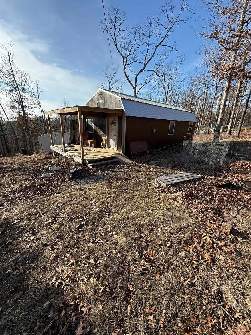 Situated on 3.08 acres, this 15x32 rustic cabin offers a simple, back-to-basics setting ideal for a tiny home or weekend retreat. The cabin features an 8-foot covered porch, open living area, loft space, and bathroom, with room to add a wood stove for cozy cabin living.  Water and electric are present on the property. A makeshift septic system was installed by the previous owner; buyer to verify condition, functionality, and permitting to their satisfaction. Property is being sold as-is. See agent remarks.