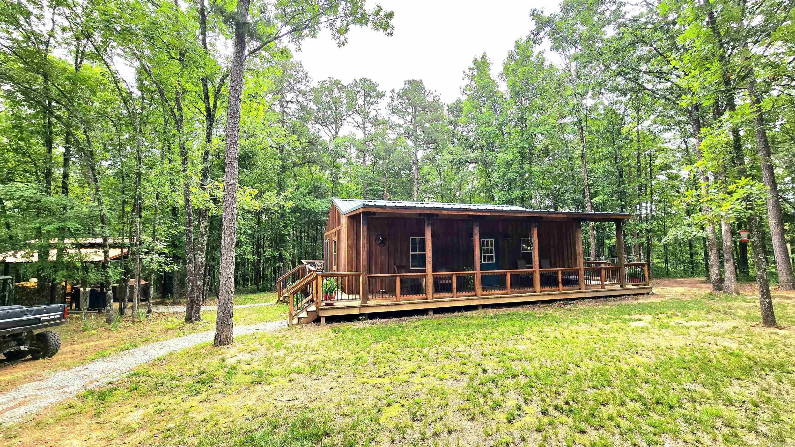 The main cabin is a 1 bed 1 bath with full kitchen, living area and wrap around deck, the 2nd cabin is another full cabin with 1 bed & 1 bath with living space and kitchenette, antique nails hold down the real wood pecan flooring, hickory cabinets hosts your dinnerware, tongue & grove cedar walls finish' off the interior walls while blue pine accents the ceilings all just a few custom details that makes this cabin a custom Ozark mtn home!! There are 2 containers with a carport sitting above to keep all your out door tools dry, 12x12ft tall door allowing you to driving into your shop with concrete floors with enough electricity to run 1 to 3 phase power! Inside you find your personal office feed by fiber internet, back that the main Cabin. The wrap around deck leads down to a custom BBQ & smoke station with LED lights that shine the way, hurry down to the slot canyon where the creeks that borders it is approx. 1/4 mile it offers multiple water flows, slides and areas to swim equaling approx. 1/2 mile of creek on this property. There is always enough to grow on this prime property. P.S. land hasn't been much hunted at all.