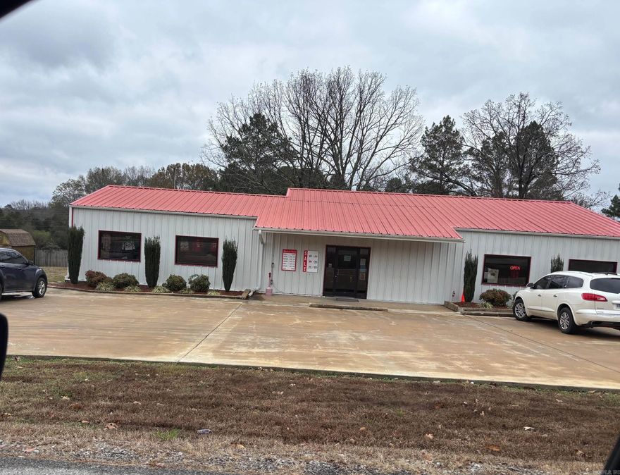 Very nice metal building with a metal roof and in a super convenient, well seen location that is not far from Searcy. Large very nice paved parking lot. The interior is all open and has tons of shelving and hanging racks and a huge cashout counter plus a separate back room for storage and sorting that could be finished out.