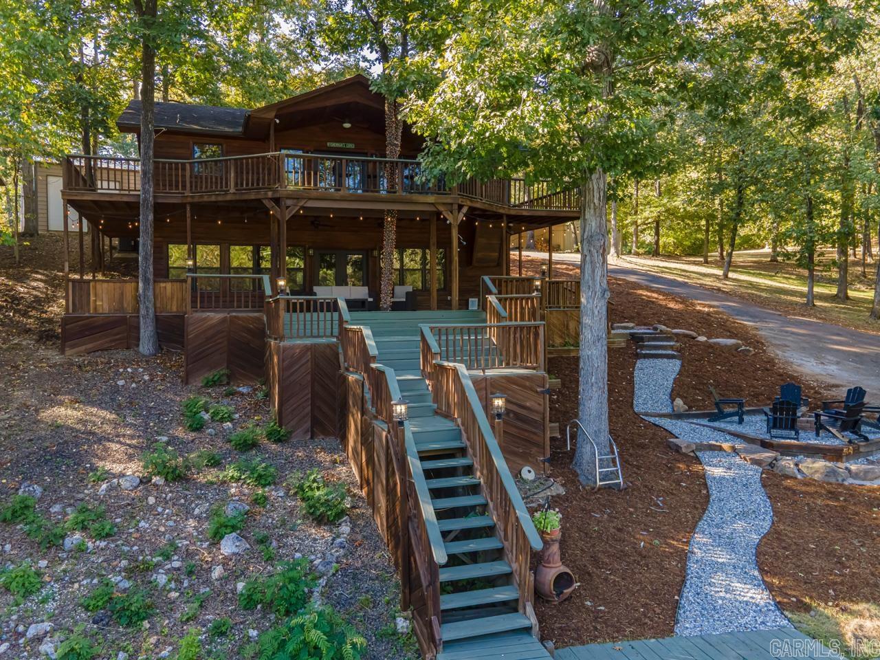 THIS LODGE IS AMAZING!! Renovated and Performing AirBnB on Lake Hamilton! In a cove, right off of the main Channel!! There is a swimming platform/dock as well as a 24x40 shop (with electric) on the property!! 3 King Size beds and 2 Queen size beds. Two Living Rooms. Over 2,000 sq ft of decks outside the home!! So beautiful and peaceful!! Make this your second home or turnkey investment property! Selling fully furnished. -Property had an enormous amount of renovations: finished out entire downstairs, tiled laundry room, custom shower in master bathroom, awesome bunkbeds downstairs, and fire pit built beside the water!