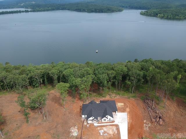 Over one acre Lakefront Lot! Enjoy the views of the lake from the big covered back porch with a vaulted tongue & groove wood ceiling. A large deck will be added for even more outdoor entertaining space. There will be room in this backyard if you wanted to add a pool later. The home is open concept with cabinets in the kitchen to the 10 ft. ceilings. The pantry is huge & will be hidden behind the cabinet doors in the kitchen cabinets. Will have a massive island with the sink in the island. The living room has a vaulted ceiling that carries out to the back porch. You will love the windows with the views of the lake. The laundry is oversized with lots of cabinets. From the laundry room you can enter the primary closet with more room than you will have clothes for. From the closet you can enter the primary bathroom. Separate tile shower & soaking tub and dual vanities. Primary bedroom is separate from the 3 guest bedrooms. Luxury vinyl flooring throughout. Lockers as you come in from the garage. The 3rd bay of the garage is extra deep (35 feet) to stow all of your lake toys and your boat. There is also room on this lot to build a shop. This subdivision is brand new. All new homes here