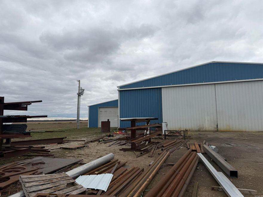 Excellent commercial opportunity on approximately 12± acres featuring three shop buildings with ample space for operations, storage, and expansion. The main shop offers approximately 12,750 square feet, ideal for large-scale equipment, manufacturing, or warehouse use. A second, mid-sized shop provides 9,360 square feet and includes an office area with a bathroom (toilet and sink), offering convenient on-site workspace. The third shop contains approximately 1,200 square feet, perfect for additional storage or specialty use. Multiple lean-to structures add even more covered storage options. The expansive acreage allows for easy access, parking, and future development. Equipment does not convey.