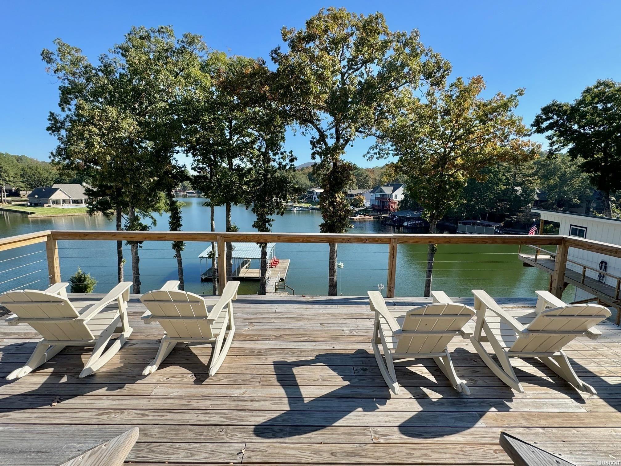 This phenomenal Lake Hamilton compound sits on a sprawling lot with approximately 167 feet of lake frontage. The main house features 3 bedrooms, 3 bathrooms, and a bonus bunk room, all fully remodeled inside and out. Additionally, a newly constructed "tree house" offers a stylish guest space complete with one bedroom, one bathroom, and a kitchen/laundry area. There are multiple decks and seating areas to kick back on and enjoy the incredible lake views. The property also includes a large two-stall covered boat dock for easy lake access. Currently operated as a seasonal short-term rental by the owners, the property presents an excellent investment opportunity. All furnishings and contents will convey to the new buyer, making this an ideal turnkey lakeside retreat.