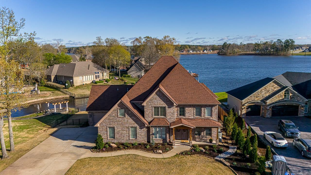 Charming craftsman-style home on Hurricane Lake with waterfront views, a boat slip, extensive landscaping/lighting, a flagstone patio/fire pit area, TREX decks off of both levels of the house, and a kayak lift! The open living and kitchen area features charming brick accents, 66" refrigerator/freezer that conveys, gas stove, wall microwave and oven, granite countertops, and a pantry that doubles as a SAFE ROOM! The lower level features a formal dining room (currently being used as an office), a cozy sunroom, bedroom, and 1.5 baths! Upstairs, the primary bedroom boasts a walk-out deck, a custom tiled shower, a jetted tub, double vanities, and his AND her walk-in closets! Additionally, there is a huge movie room (tv conveys), 3 more bedrooms, all with baths, & a laundry room with coffee station! PLUS Plenty of attic storage, a hidden exercise room (w/mini-split), dog wash area, automated interior/exterior lights & thermostats, alarm system, sprinkler system, tankless hot water, Gearwall storage in garage, Enterprise level networking hardware, robust wifi network with multiple access points and security cameras that convey!