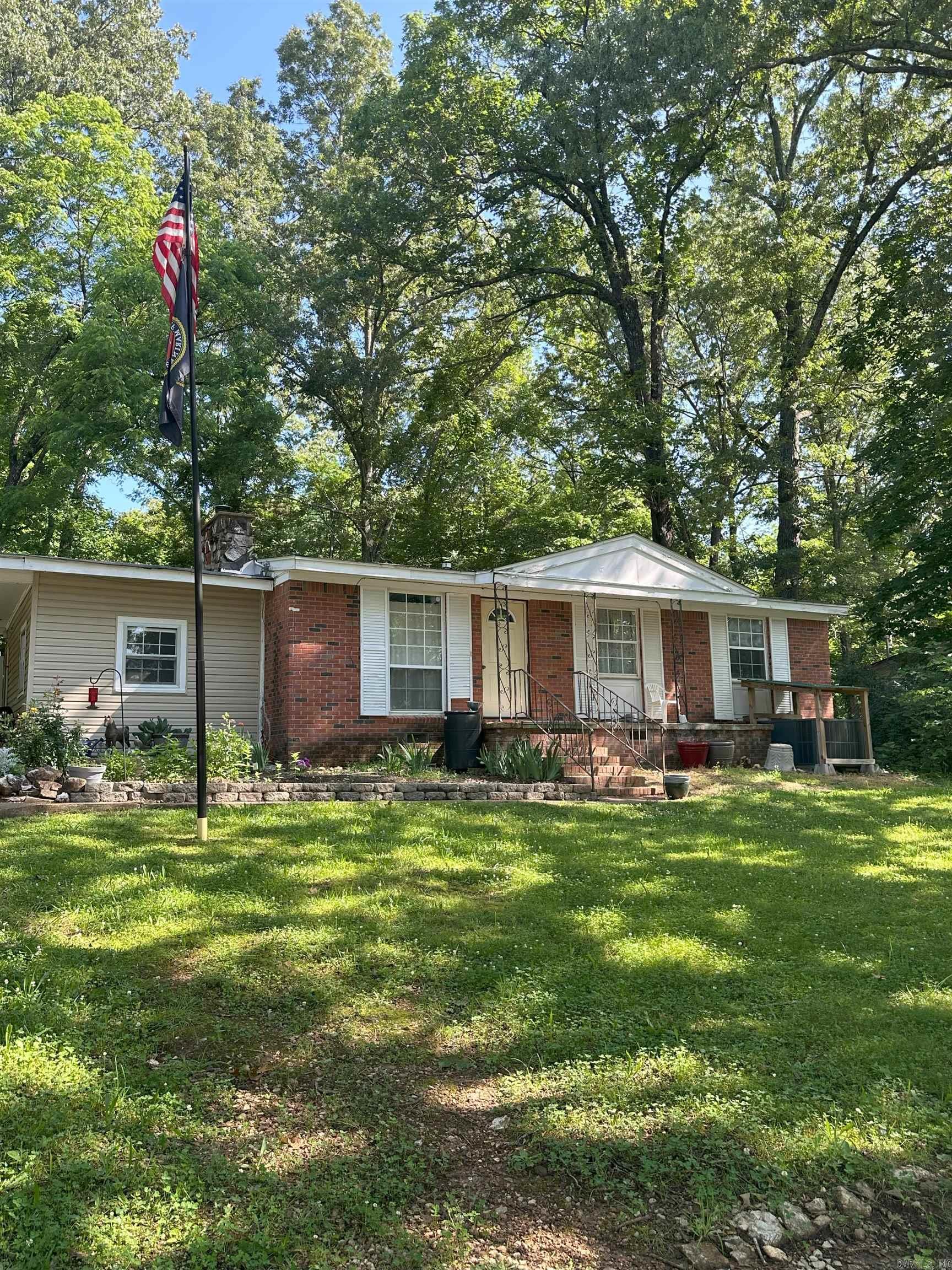 If you are looking for a smaller house with a big big yard on a corner lot this may be the one! Cozy bungalow type house with 2 adjoining lots. 3 bedrooms, 2 full baths, eat in kitchen and fireplace. Newer HVAC system and water heater. Beautiful accent wall in living room. Laundry room is separate and can double as a mudroom from carport. New flooring in kitchen, but the rest of the house is original hard wood floors. Cherokee Village amenities include 15 parks, 7 recreational lakes, 2 golf courses, a pool and the list goes on! Don't miss out today on seeing this home. Agents See remarks.