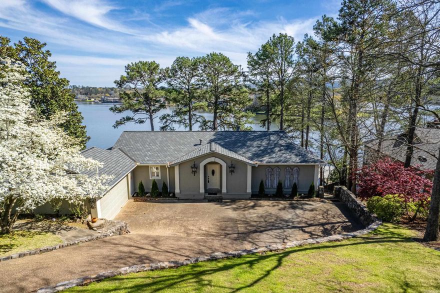 This Lakefront Beauty is situated on a South Facing Lot featuring Gorgeous Views of Lake Hamilton and Mount Riante! The Floor Plan is Comfortable and the Walls of Windows take Full Advantage of the Views - from Every Room... The Main Level features the Great Room, Kitchen and Dining + Breakfast Area, Laundry and the Primary Suite, while the Lower Level Offers 2 Guest Bedrooms (one with an Ensuite) in addition to a 3rd Full Bath and a Den. The Main Level Covered Patio Steals the Show with 180 Degree Views! The 2 Stall Boat Dock is Stationary and Offers a Swim Platform. Nice Seawall. Open Water just off of the Main Channel. Sprinkler System, Extensive Landscaping & Stone Patios. This Home is a GEM!! Enjoy the Fireworks on Summer Holidays, Year Round Deep Water and Beautiful Sunsets! This Property is Fully Fenced and Gated. Appointment Required. Call Today for a Private Showing!