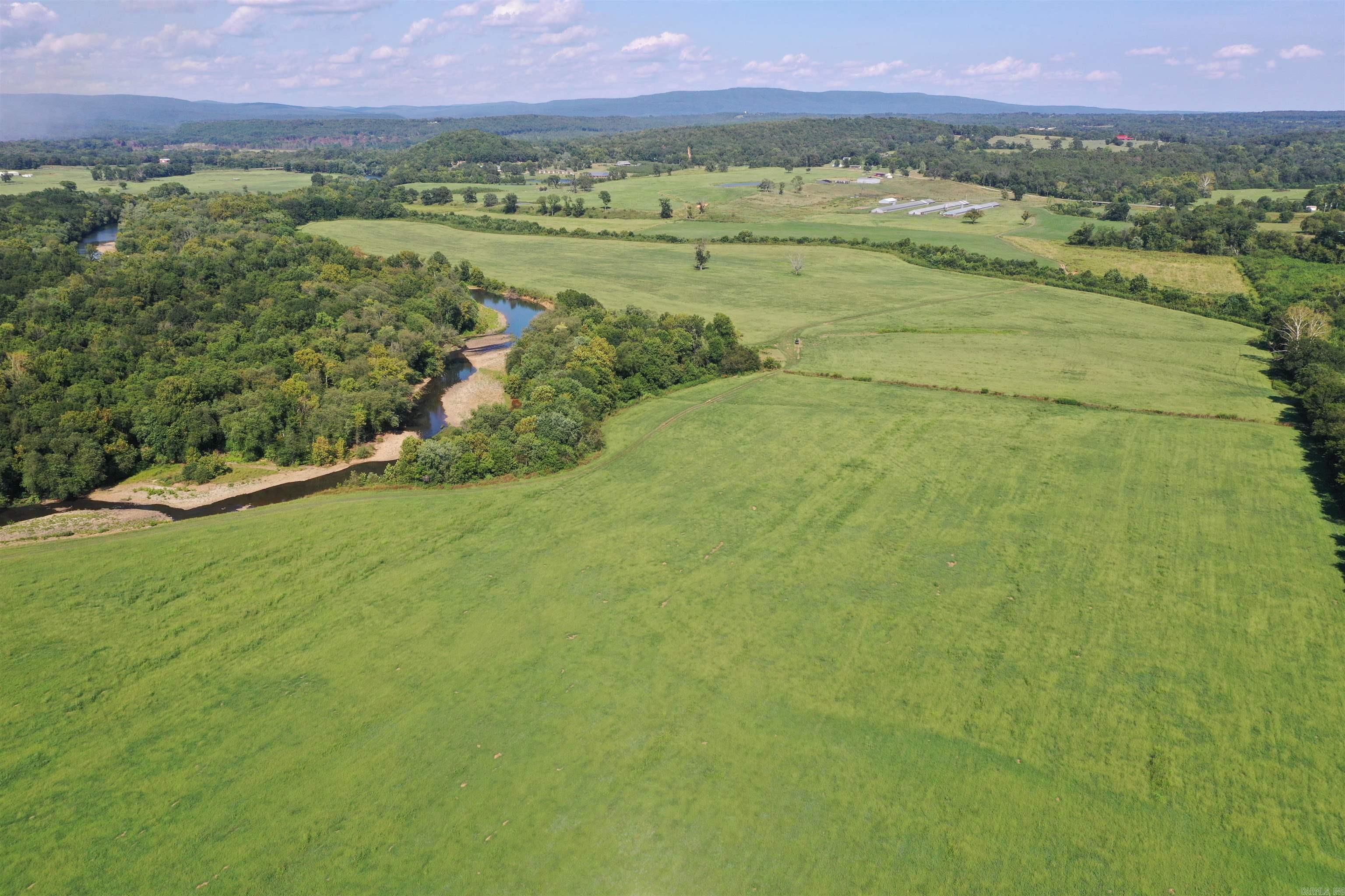 This Beautiful Pope County farm has multiple improvements to benefit your farming operation on many different levels! Sprawling a vast 283 +/- Acres and being composed of nearly all hay meadow and grass pasture, this well-maintained farm has been groomed with productivity in mind. Along with the three-house poultry operation, the farm has great recreational opportunities along the spectacular Illinois Bayou. • 283 +/- Acres • 1 Mile of Year-Round Illinois Bayou Frontage • Three Poultry Houses with Current Tyson Contract • Newly Constructed 40x80 Litter Shed • 60x80 red iron barn • 2010 Model 2128 sq. ft. Mobile Home • Newly Constructed 40x60 Horse Barn • Cattle Improvements • Fenced, Cross Fenced, Automatic Frost-free waterers • Two ponds • Pipe Corral with multiple sorting pens • Fertilized and well-maintained hay meadows • Great Build sites and views • Pipe Fencing • Great Fishing, Hunting, and recreational opportunities • Tractor and Implements conveying with sale • 90 HP Kubota cab tractor • Kubota Hay Baler • Kuhn V Rake • 4 Basket Kuhn Tedder • 200 Gallon Sprayer • 15 Foot Batwing Bush hog • Two Kuhn 9-foot hay mowers
