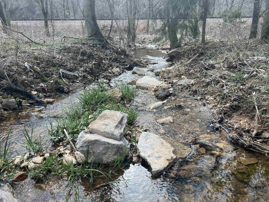 Nice CREEK with 4.08 acres m/l with county road frontage. This property features NO restrictions, hardwood trees, small hunters cabin, shed, and would make a good spot to build. Come take a look today.