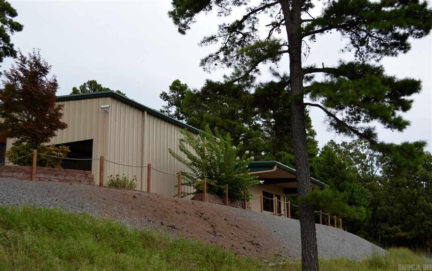 Breathtaking view of Lake Maumelle and the valley.  Nestled into the hillside on Dwight Little Road surrounded by evergreens this home would make a wonderful weekend or daily retreat.  Tile runs throughout the home, slab granite in the bathroom and kitchen adorns the stained Thomasville cabinetry.  Kitchen is open to living room with unobstructed views.  Extremely oversize heated garage with RV door is large enough for cars and more.  Security cameras and alarm system convey.