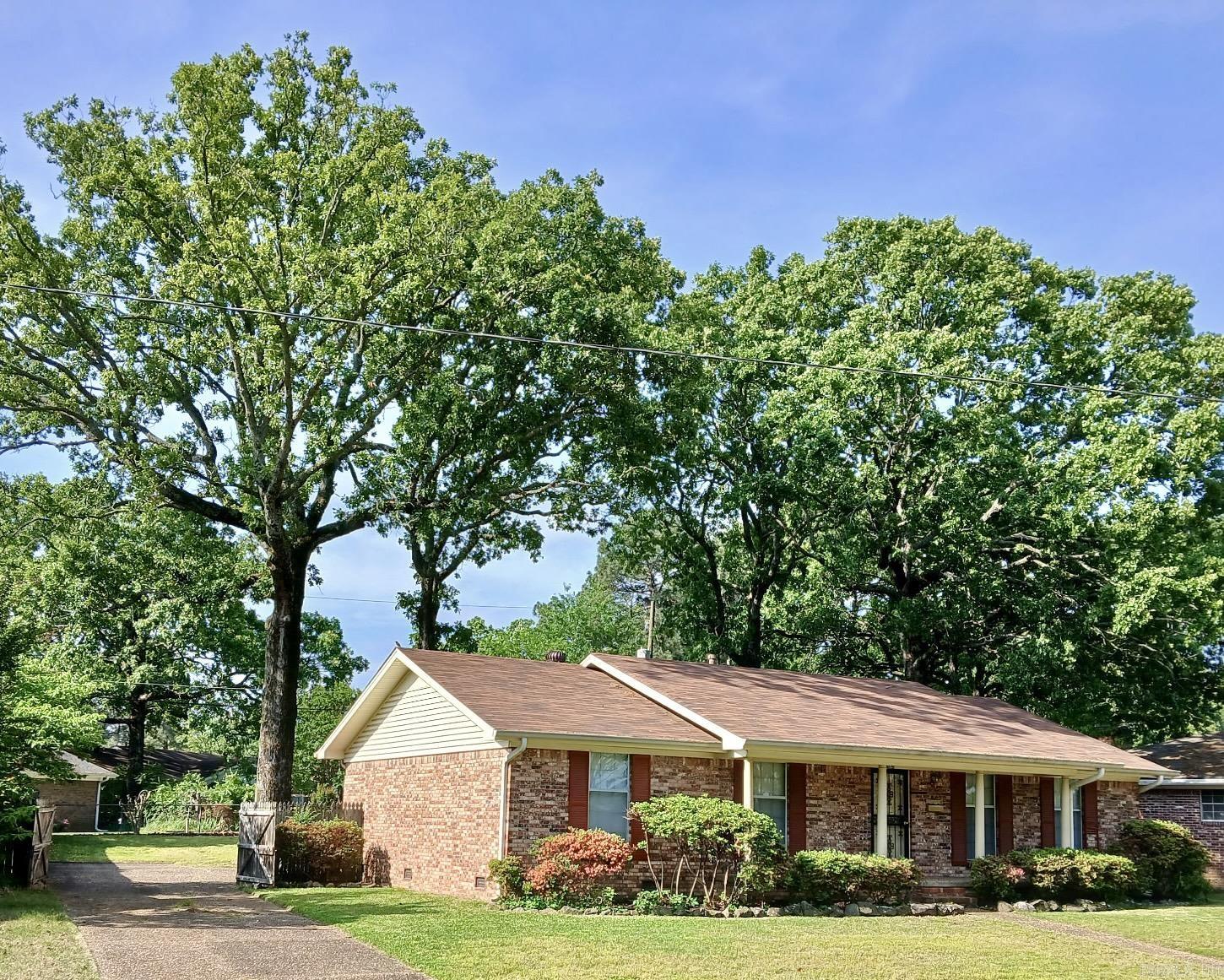 Decades longtime owner, well taken care of and loved... and it shows! Living area w/ fireplace opens nicely to dining and kitchen areas. Bright, white kitchen features updated flooring, lots of pretty cabinetry plus a pantry. Big utility room with extra cabinetry. Large master suite with two closets and tiled, full bath. Tiled hall bathroom w/ large vanity serves second and third bedrooms. Spacious extra living/ dining area could be game/ playroom, office or second living area. Fresh interior paint through-out. Low maintenance brick/ vinyl siding exterior. Private, rear double carport. Outside storage building w/ electricity. First American Home Warranty. Situated at the back of a convenient area, this is a terrific house!