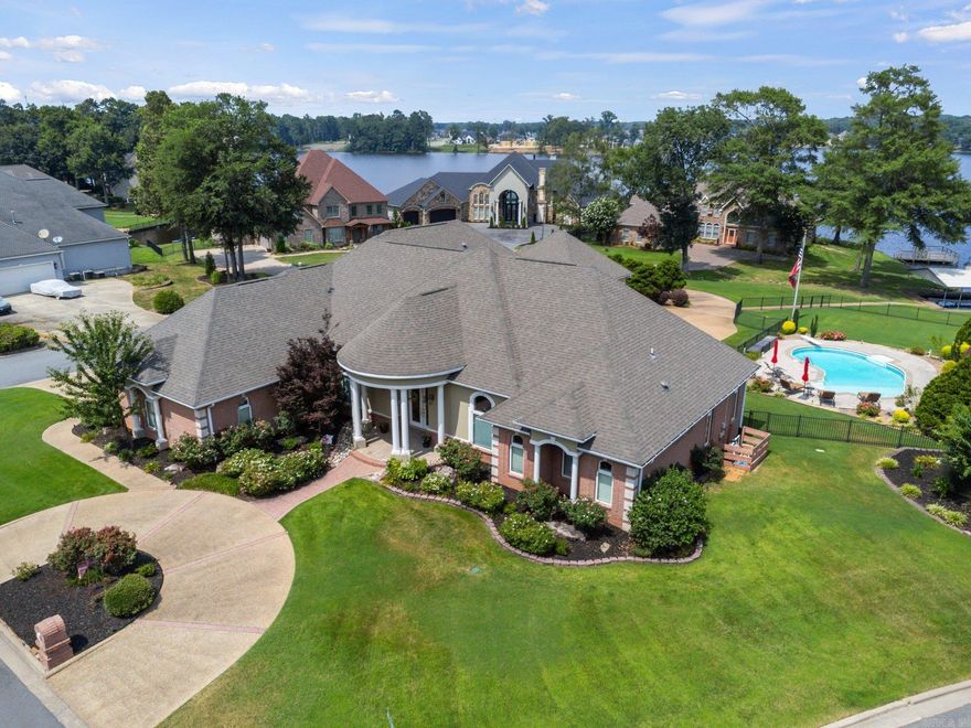 EXQUISITE ONE STORY HOME BUILT ON 2 LAKE LOTS! House sits on a cul-de-sac street on almost 1 acre with amazing privacy. Views of the lake from almost every room, saltwater pool, covered 2 slip boat dock, attached 3 car garage and separate 755 sqft 2 car shop/garage that is heated/cooled/insulated for a total of 4404 sqft heated/cooled space. Covered veranda overlooking courtyard fountain, pool and lake. Seawall w/sidewalk from house to lake. Extra-large luxurious master bedroom with new hardwood floors, renovated master bathroom with heated floors, double closets. Separate ice maker and refrigerator in wet bar. Two sprinkler systems. Generac whole house generator. New roof 2014, new HW tanks, new garage door motors, custom drapes added, iron fence work, new kitchen appliances in 2020. Two new HVAC systems with 15-year warranties in 2023. House was repainted along with all white trim and white columns in 2021. New salt cell for pool in 2023. New Bluetooth Security Cameras installed in 2023. New Bluetooth Exterior Permanent Lighting around house, detached garage and courtyard in 2024. Seawall was repaired and cleaned in 2024. Too many features to list...it's a must-see!