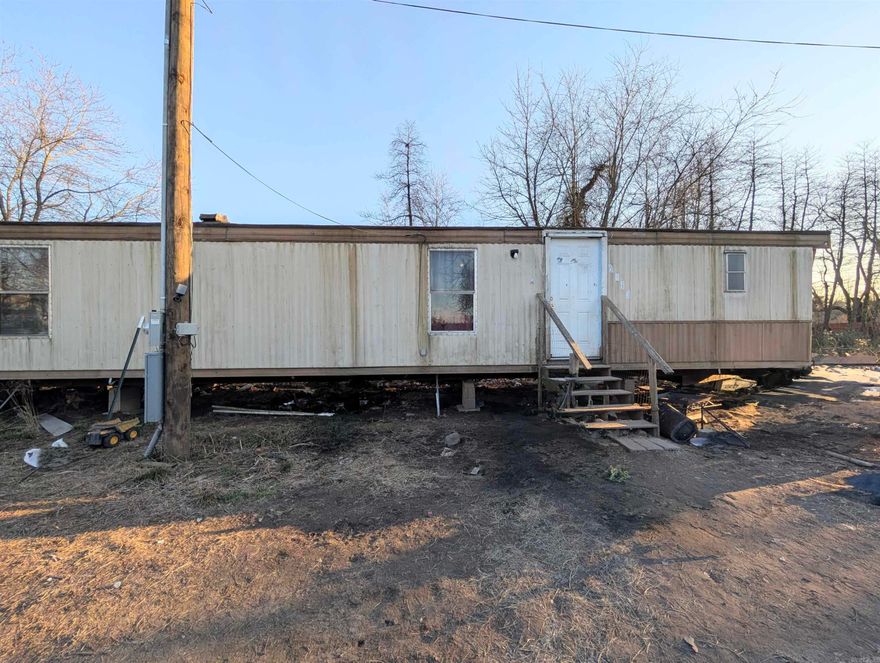 This property has fantastic mountain views! The fixer-upper home has limitless possibilities, as it sits on a level lot. Hard to find piece of small acreage, utilities are available, but not connected to the property. Mobile home does not have underpinning. Agents see remarks.