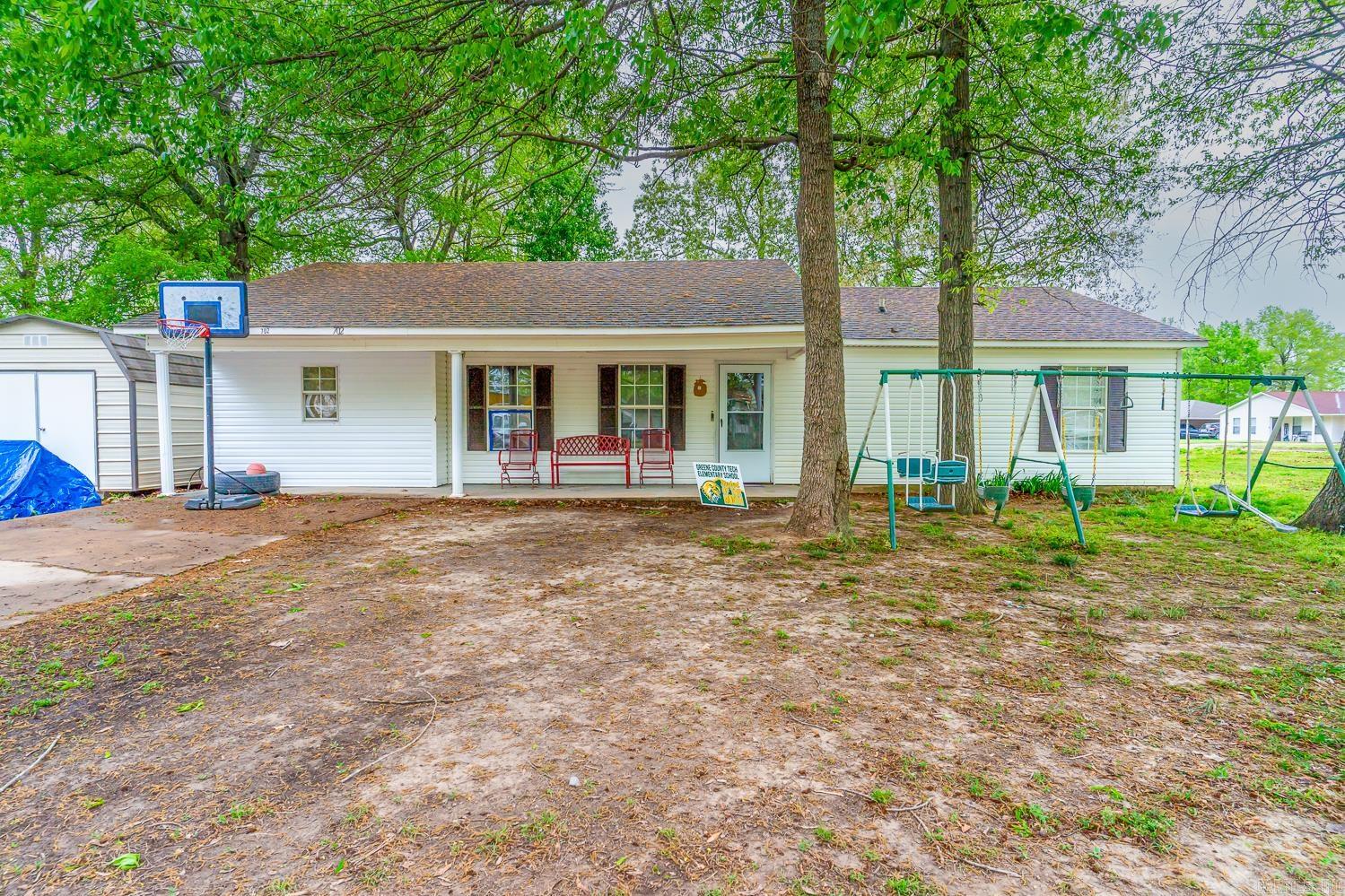 Great house on a corner lot, tucked away in central Paragould, close to downtown entertainment and shopping. Entering the front door into the living area, ahead is the dining area and kitchen with island/breakfast bar, through the laundry room is the former garage, converted to an extra bedroom. Down the hallway from the living room you will find a full guest bathroom, and three bedrooms including the master which has a full bathroom. The house sits on a double lot, totaling 0.46 acres. Currently, a small section outside of the back patio is fenced off with wire fencing.