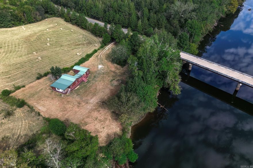 *Unique and rare property on the Ouachita River* Site built log cabin on 1.6 acres is a nature lovers dream, ideal for fishing, kayaking, canoeing or just to enjoy the serenity and beauty of mother nature . The cabins feature beautiful knotty pine tongue and groove walls with rustic tin ceilings. The main cabin features an open concept living area and kitchen, XL storage/utility room, 2 bedrooms and bathroom. The 3rd bedroom with bathroom is in a separate cabin connected by a breezeway making this setup ideal for short term rentals or multi-family vacations. Surrounded by pastures, the property offers privacy and seclusion including fencing and gates, as well as a storage area with electricity for all your water toys. Located right across the river from the Grigsby Ford boat ramp and less then 10 minutes from I30, it's convenient to access whether to live, play or invest. Close proximity to Hot Springs and Oaklawn, this would be perfect for an Airbnb.