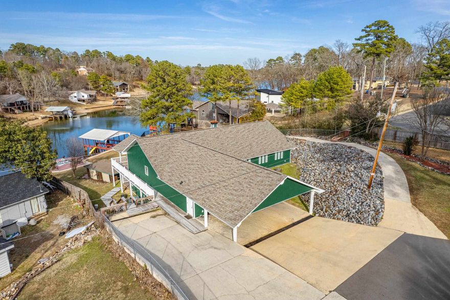 Two complete homes under one roof! Discover this waterfront retreat in idyllic Tanglewood Subdivision. Upper and lower floors can function as a large single-family home or as two fully-equipped residences. This custom design affords unique opportunities, including multifamily purchases, hosting groups, or living on the main level (2,770 sqft) while utilizing the lower level (2,310 sqft) for income. Each level has a complete kitchen, laundry facility, large den + dining area, 792 sqft covered porch, and private entrance. With two separate heat/air units and meters, you choose what to heat and cool based on your needs. Interior highlights include relaxing views from large windows & glass doors; main floor primary suite (with an unbelievable walk-in closet!); dedicated office with water view; soaking tubs & custom walk-in showers; and a wood-burning fireplace. A paradise for both adults and children to enjoy with a sprawling 150’ of Lake Hamilton frontage, a 2-stall covered boat dock, XL swim deck with steps into the lake, charming cabana, a private fully fenced park, and paved golf cart path. 2 outbuildings + 1,500 sqft walk-up attic. Begin living your perfect lake life.