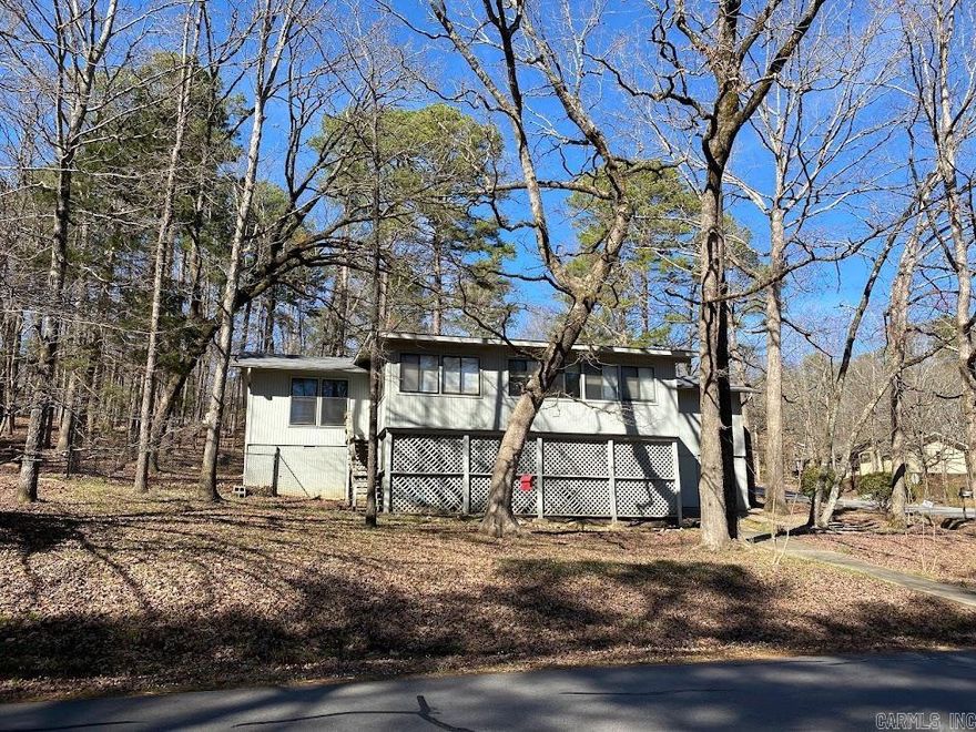 Tucked in the woods with fenced yard, carport, split floor plan, open concept, fireplace! Sunroom makes this open space roomy and inviting., Room off of sunroom makes for additional office or music room. Jack and Jill guest bedrooms and bath with tub, very spacious! Wide driveway, outside storage in carport and under home in golf cart garage. Located near the West gate for easy travel to anywhere! Enjoy the hiking trails just outside your door and more!