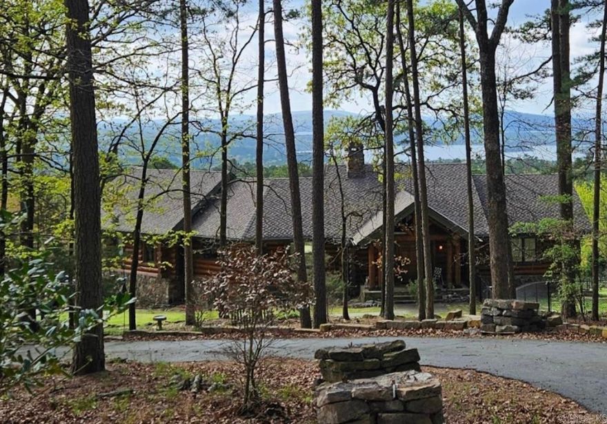 Immerse yourself in the breathtaking million-dollar views of Lake Maumelle and Pinnacle from this custom-built home, set on a generous 15.99 +/- wooded acres in Roland, AR, close to Little Italy. Experience complete privacy just minutes away from vibrant West Little Rock – truly the best of both worlds! This sophisticated log home is crafted with Englemann Spruce timber using the exquisite Swedish cope technique, featuring numerous special touches displaying expert blacksmith craftsmanship. The main level boasts a living room and a second bedroom/office adorned with a tongue & groove vaulted ceiling. The living room offers a striking double-sided dry stacked stone fireplace, accompanied by stunning views. The inviting kitchen and hearth room/dining area showcase beautiful cypress flooring, a sleek granite island, and a convenient gas stove, making it perfect for cozy gatherings. Don't miss the opportunity to own this extraordinary residence. Contact us today to schedule a private tour and see the magic for yourself! Agents, please see confidential remarks.