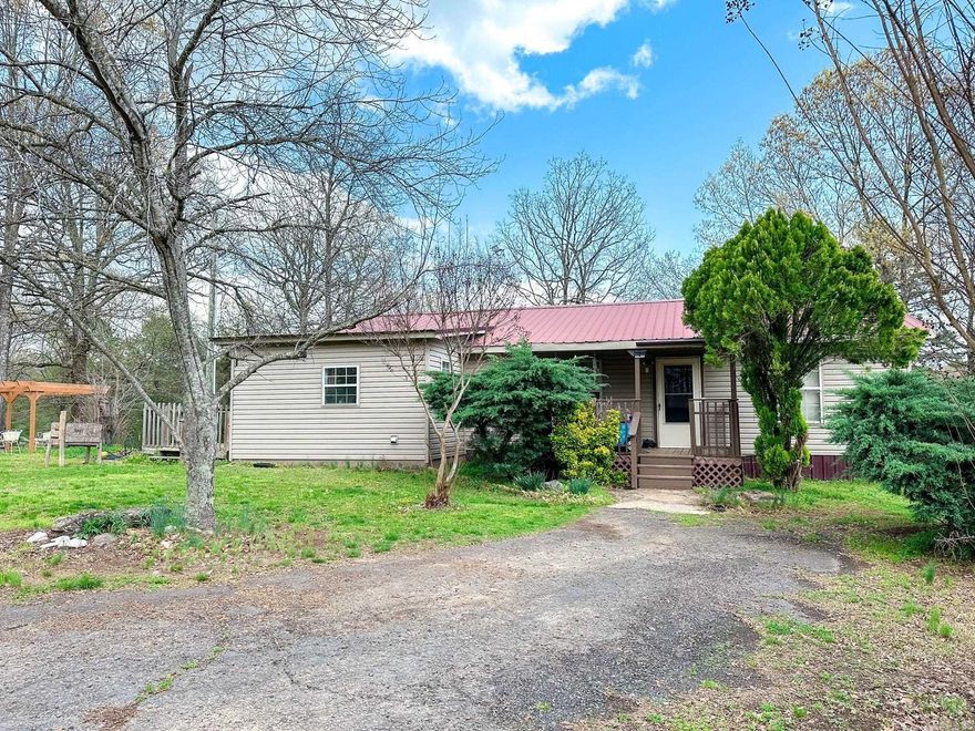 Tucked away on a peaceful 20-acre spread, this 4-bedroom, 2-bath home offers the perfect blend of privacy, functionality, and charm—all within city limits! With a spacious layout that includes a dedicated office, a mud/laundry room, and generous living area, there’s room for the whole family to spread out and stay organized. Outside, you'll find two carports, a storm shelter for peace of mind, and a small shop for your projects or hobbies. There is also an unfinished cabin on the property that would make the perfect she-shed, man cave, or guest retreat. The property features a pond and two natural springs, adding to the scenic beauty and homesteading potential. Whether you’re looking for a mini farm, a private retreat, or space to grow and play, this property has it all—country vibes with the perks of city amenities just minutes away. Home has no septic. Seller credit will be issued for a septic. Agents see remarks.