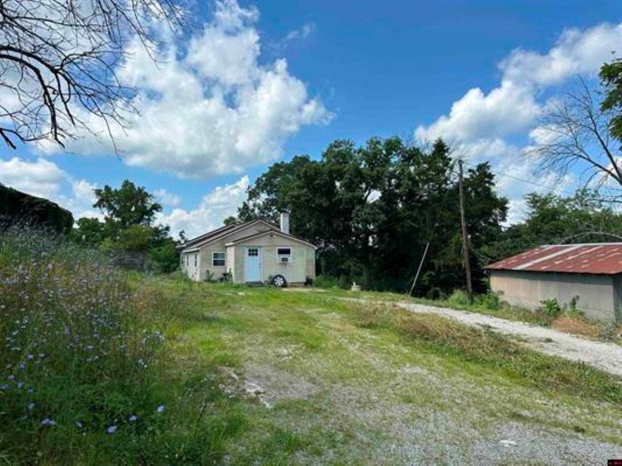 Older country home with 3 bedrooms and one bath is from the sixties and has low ceilings to conserve heat. It has a newer metal roof with heat and cooling from a singular window unit. Property had pasture at one time but it has grown up and in need of TLC. The access is off paved highway 125 and property is very near canoe launch site on Crooked Creek in Marion County for smallmouth bass fishing and for canoeing and kayaking. Located about 7 miles out of Yellville where there is groceries, gasoline, hardware store, churches and restaurants. Twenty acres m/l with home available for $84,500. Shown by appointment.