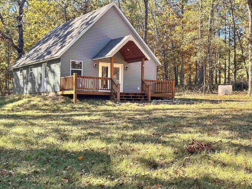 Discover this quality, custom-built, one year old cabin in the woods on 10 acres m/l of pure serenity. Designed with a gorgeous open concept, the interior boasts stunning vaulted beamed pine ceilings and walls that create a warm, rustic atmosphere. The main floor features a primary bedroom en suite with walk in shower.  There's also a separate powder room for guests.  A truly unique loft space provides both a sense of privacy and the flexibility to easily sleep an additional four people, making it perfect for guests. The kitchen features stainless steel appliances and is complemented by a generous laundry space down the hall that includes a great storage closet. Enjoy the peace and quiet of your completely private and secluded woodland escape, where abundant wildlife sightings are a daily pleasure. Despite the tranquility, you are conveniently located close to the natural beauty of Big Creek and are within just two miles of doctors, shopping, schools, and more. This is a must-see for anyone seeking the perfect blend of luxury, nature, and convenience.