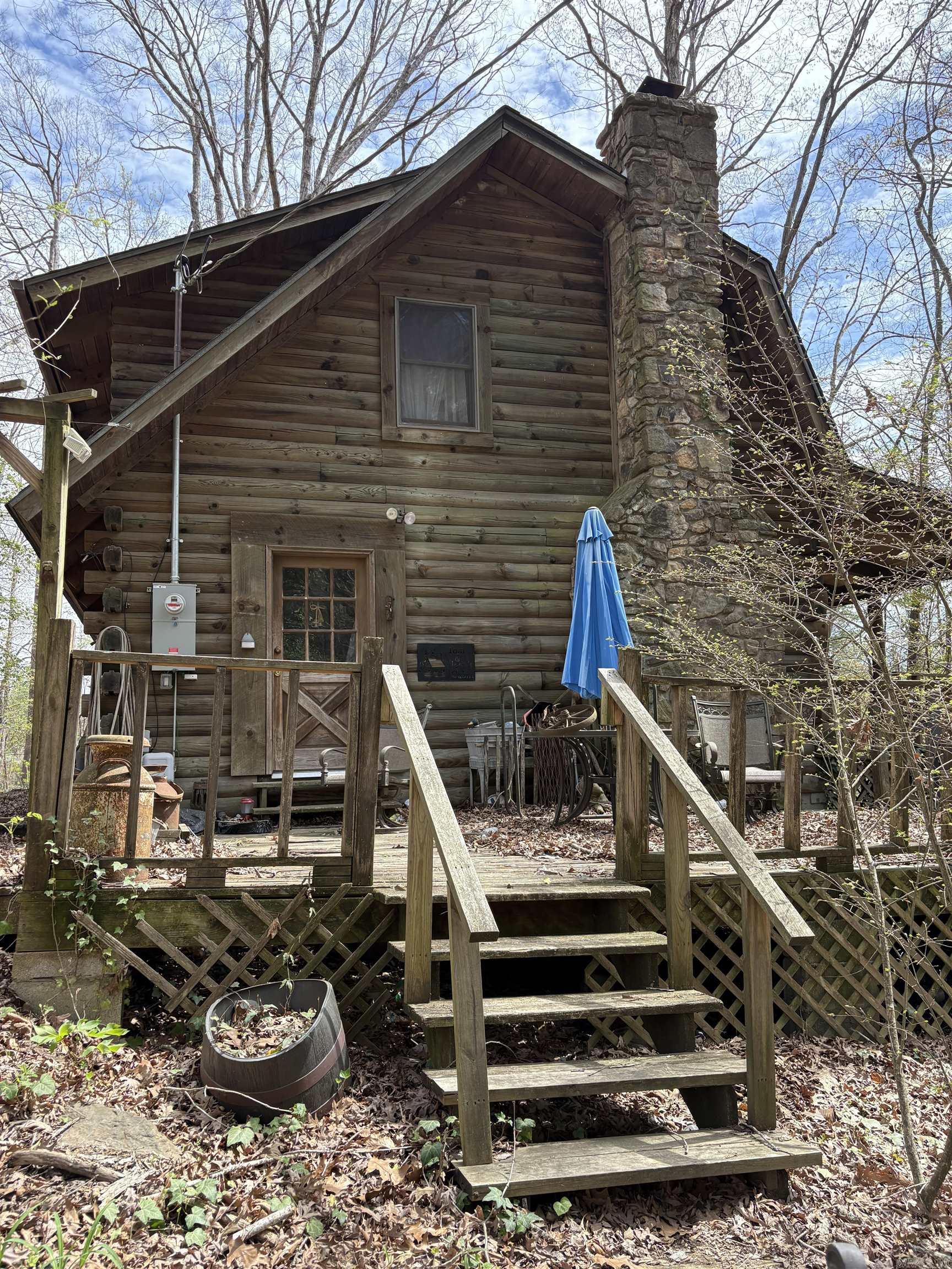 Price change. Log home with wrap around decks, fireplace, and cathedral ceiling. Being sold AS Is. Recent updates include a new roof (installed a year ago) and an upgraded electrical box. The outdoor space is a true retreat, featuring porch swings, outdoor furniture, and regular visits from wandering deer. Inside, the washer, dryer, and refrigerator stay, while the home boasts a collection of antiques and collectibles that add a unique touch of character. The spacious basement is plumbed for a bathroom, offering great potential, with an old-fashioned bathtub present but not yet hooked up. Additional improvements include a new water heater (installed last year) and a new AC unit within the last three years. While the home requires deep cleaning and some repairs, the primary bedroom features a walk-in closet, and a versatile additional room on the main level can serve as a bedroom or office. This home offers a perfect blend of rustic charm and modern conveniences, making it an excellent opportunity for someone ready to invest in a this home is perfect for anyone ready to invest in sweat equity.