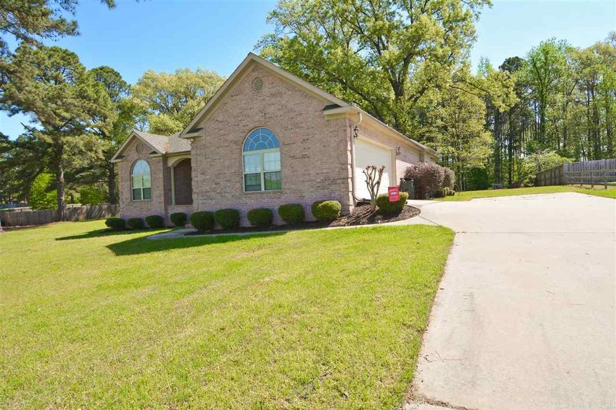 All brick on 1.23 acres. Up slope lot with perfect setting for home. Nestled in front of gorgeous oak trees to shade large back yard and deck. Split plan with side entry garage. Living room has recessed lighting, tray ceilings, gas fireplace, stained concrete floors and wall  of windows to back yard. Entrance has wood floors into office. Lots of crown moldings, pantry, island with drawers, breakfast bar in kitchen.