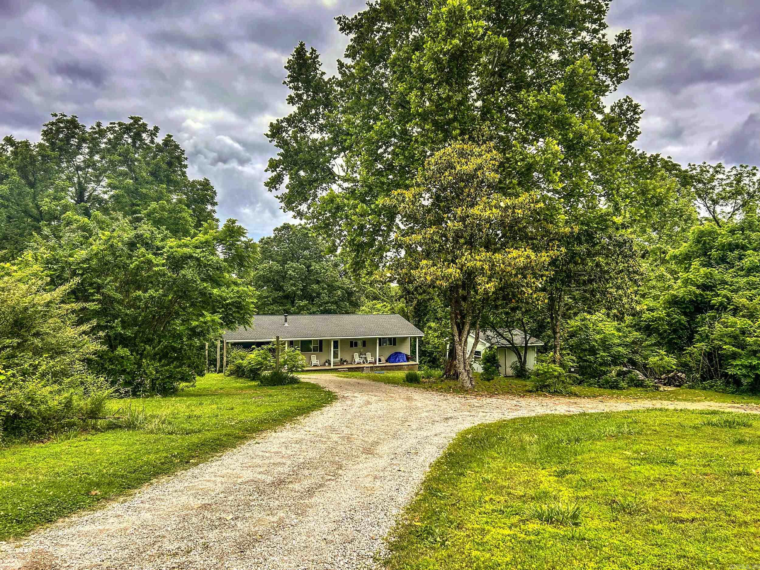 Situated on 5+ unrestricted acres, this cozy 3 bedroom, 1.5 bathroom home sitting at the end of a quiet dead-end road just minutes from town offers privacy and convenience. Featuring LVP flooring, new shingles in 2024 and a utility building for extra storage or workshop space. The welcoming kitchen is equipped with a gas stove and open to the dining area. A separate laundry room with pantry space adds functionality. Enjoy the covered front porch and quiet views from the raised deck overlooking the large, private backyard. A wood-burning stove adds extra warmth and charm during cooler months. The circle driveway offers extra parking. This is your opportunity to enjoy quiet country living with no restrictions.