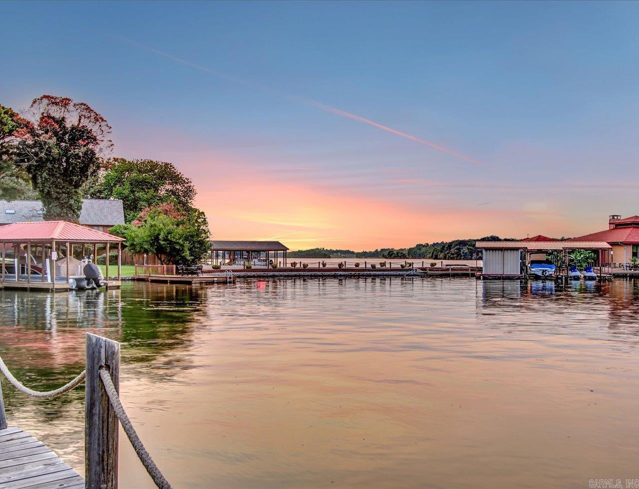 LAKEFRONT CONDO WITH THE BEST LAKE VIEWS AND A DOCK! Enjoy scenic views of Lake Hamilton, on this quiet cove, from the picture windows and private balcony of this 2 bed, 2 bath beautifully situated top-level end unit at Farr Shores. This lakefront gem is ideal as a short-term rental, vacation retreat, or full-time residence. Farr Shores has an on-site caretaker and offers a lakeside swimming pool, tennis courts, private boat ramp, boat trailer parking, and a boardwalk perfect for fishing or evening strolls. Nightly rentals are allowed, making this an excellent investment opportunity. Inside, cozy up by the fireplace in the living room on cool mornings and evenings. The primary suite offers direct balcony access—wake up to the lake view! An in-unit laundry closet for convenience. A spacious, covered patio with plenty of room for seating for lake entertainment. Boat slip and off season boat storage is included. Just a short drive to Oaklawn Racing & Casino, historic Bathhouse Row, Magic Springs, National Park hiking trails, etc. Everything you need in a lakefront condo! COME AND SEE!! Agents - please schedule all showings with Showing Service.