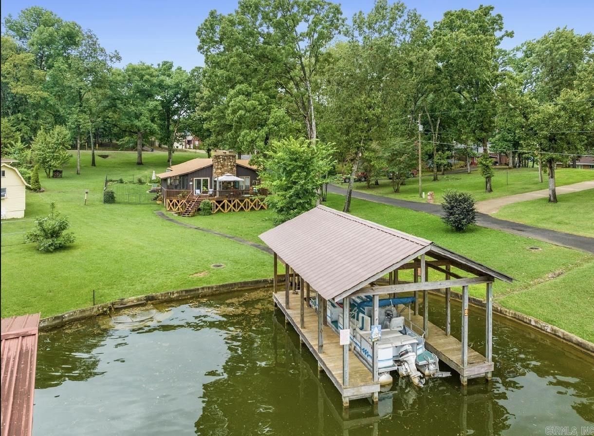 Wonderful gem on Windy Point that sits on almost an acre lot with main channel views and a single stall boat dock ready to make yours. This 3-bedroom 2 bath house features a lakeside patio and screened in porch, where you can soak up the sun and enjoy the views. It has an updated kitchen along with additional oversized game room/craft room. You will also enjoy the huge storage/workshop with pegboards and workbenches ready for your next project. This property is situated in a cove with walk in steps, it is the perfect place to kayak, paddleboard, swim or fish.  Expansive .88 acres nestled amongst million-dollar homes in quiet neighborhood has plenty of room to expand and tons of potential!  Located in the county and STR allowed