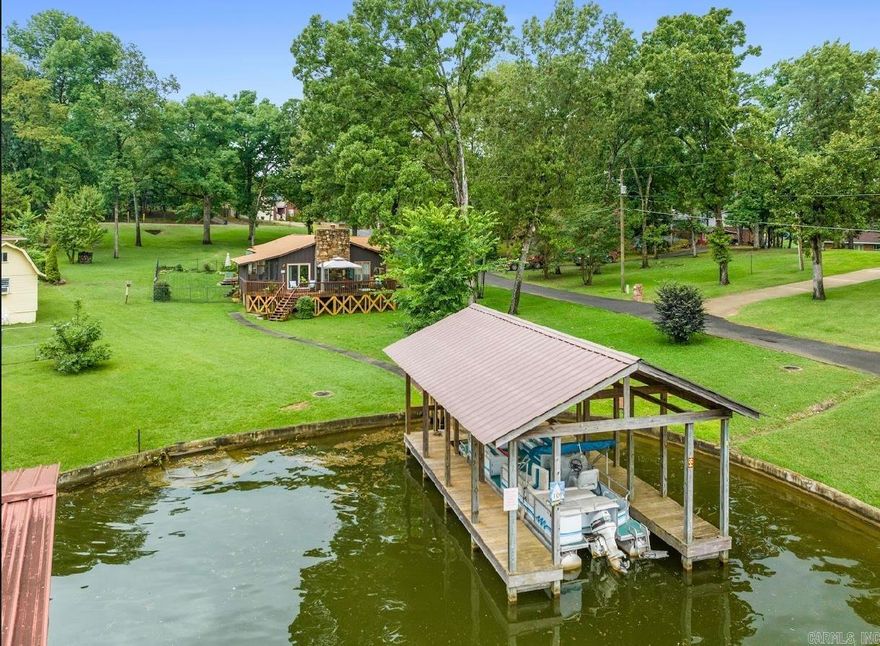Wonderful gem on Windy Point that sits on almost an acre lot with main channel views and a single stall boat dock ready to make yours. This 3-bedroom 2 bath house features a lakeside patio and screened in porch, where you can soak up the sun and enjoy the views. It has an updated kitchen along with additional oversized game room/craft room. You will also enjoy the huge storage/workshop with pegboards and workbenches ready for your next project. This property is situated in a cove with walk in steps, it is the perfect place to kayak, paddleboard, swim or fish.  Expansive .88 acres nestled amongst million-dollar homes in quiet neighborhood has plenty of room to expand and tons of potential!  Located in the county and STR allowed