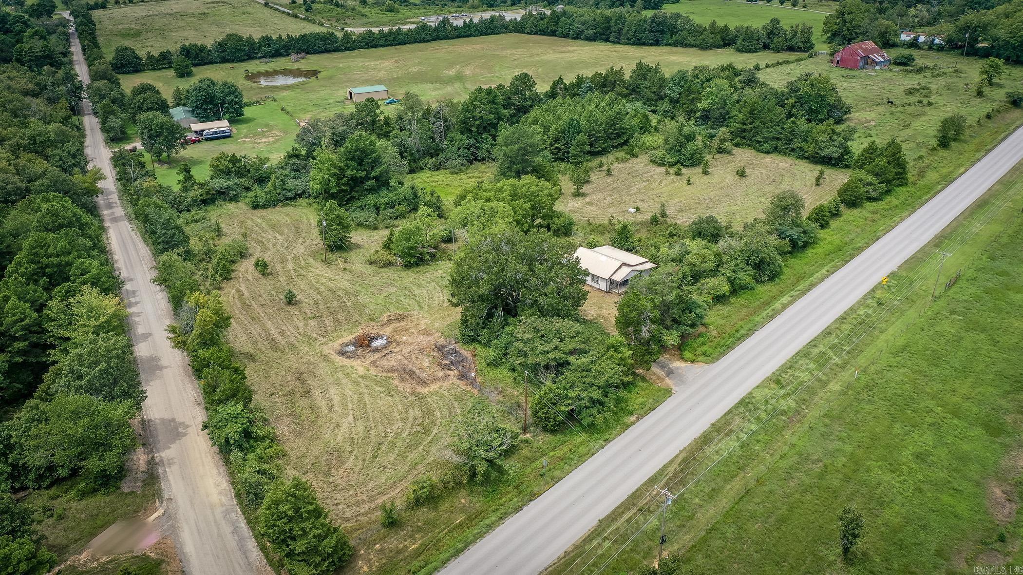 APPROX 4.66 ACRES WITH A FIXER UPPER. THERE IS AN OLD POND THAT IS DRIED UP, FENCING AROUND MOST OF THE PROPERTY. PROPERTY IS BEING SOLD AS IS.