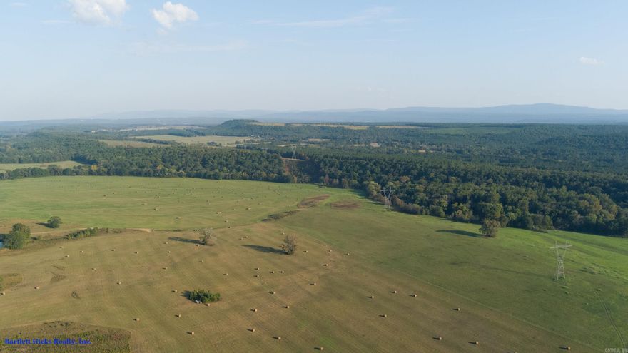 This property is a rare find, spanning a substantial 1287 acres. I have explored the land thoroughly, and it truly is a hunter's paradise, featuring open fields along the Petit Jean River and backing up against the mountain. Currently, all the fields have been cut for hay. During our last visit, I noticed that the fields had just been hayed, attracting all kinds of wildlife. Quail would be a great addition to this property; in fact, there are already a few present, along with deer. The wooded areas also invite turkeys. Accessing the roads leading to, through and from the property is easy. Additionally, there are several sheds on the property that are used for storing tractors and hay. Just minutes from conveniences in Booneville.  In the event you want to build your dream lodge, the site is only a hop, skip and a jump to Fort Smith shopping.  Don't miss out on this opportunity, and as the country and western song says, "Buy Dirt."  Last count on large round bales of hay was 835+