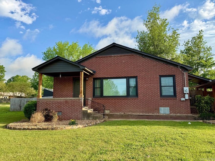 2 bedroom, 1 bath brick home on approx. .33± acre level lot in Mena, AR. Built 1960, offering approx. 1,580 sq ft of comfortable living space. Refinished hardwood floors and tile in the kitchen, bath, and laundry create a clean, cohesive feel. The kitchen features granite countertops, a gas stove with oven/air fryer, and new stove and refrigerator (2024). Move-in ready, with roof and interior paint updated in 2025 and windows replaced in 2023. Inside, you’ll find a welcoming living area, an additional sitting room, and a custom walk-in shower. Outside, enjoy a private covered porch, fenced backyard, storage building, detached carport, bricked patio, and low-maintenance landscaping (2025). The home sits back from the road on a large lot, offering a sense of privacy. Approx. 1 mile from the new Mena bike trails and close to downtown Mena and shopping, so you can head out for a ride or errands straight from your front door.