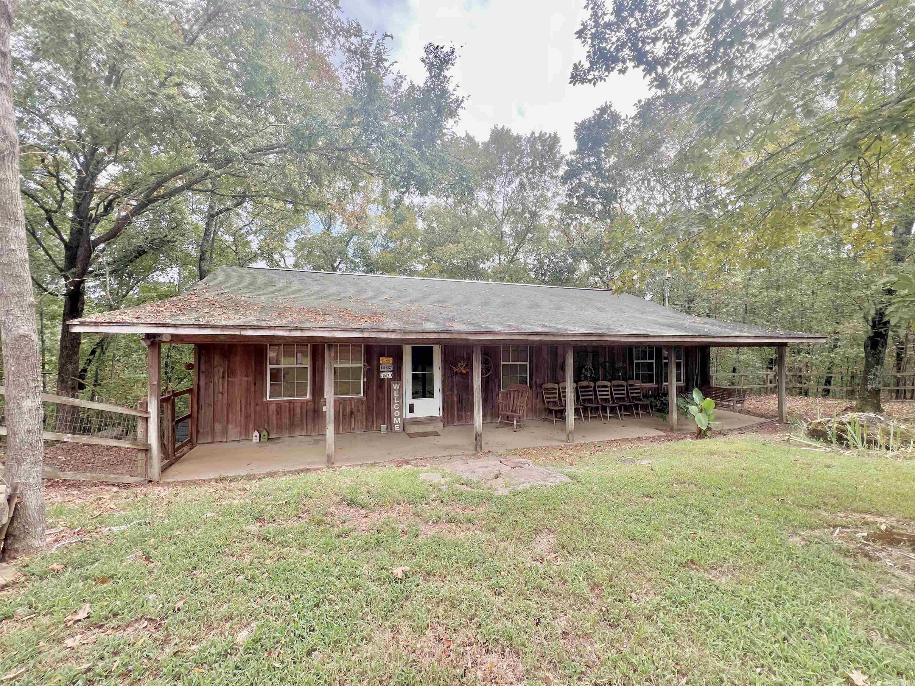 You've found your cabin in the woods! This rustic style home sits on 3.95 acres and is secluded for privacy. Road frontage is level while you have the sloped wooded terrain along back of property that leads to a creek. This 3 bedroom 2 bath home has a great floor with a semi-open floor plan. The large porch invites welcomes you to the front of home, where once inside you'll find beautiful earth tones, wood floors, warm fireplace, and more. The kitchen offers an abundance of cabinetry with stainless steel appliances. Just off the dining room you'll notice the access to the back deck and double doors to the walk-in pantry/laundry combo. All 3 bedrooms provide ample space with closets. Be sure to check out the beautiful copper sinks in both bathrooms. Primary bedroom also has a large closet.