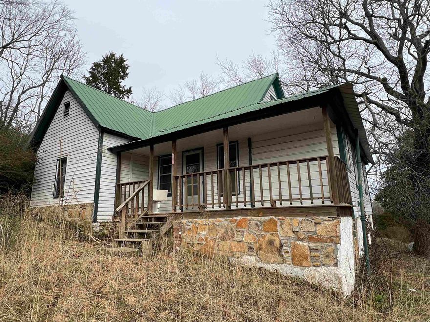 Are you looking for a house to flip?  Maybe you are looking for a place you can fix up and use as a nightly rental?  Or just maybe, you are looking for a place to live in the Ozarks of Arkansas near the Buffalo National River?  These are just a few of the reasons to take a look at this 2 bedroom, 1 bath home in Marshall Arkansas.  Located on 3 lots, this home sets just off Highway 65, perched above Church Street.  The house and property have great potential to be a beautiful historic home with chicken coop in the back yard and garage to the side of the house.  There is also a partial basement with outside access.  The remodel is underway on this house, but it is ready for you to finish with your vision for what it can be.  The floor coverings currently in the house are carpet and hardwood.  Did you see the old newspaper floor covering in the kitchen?  The living room is spacious with plenty of area to relax.  The bedrooms are good size with great closet space.  Off the living room is a nice deck with great views of the hills to the East.