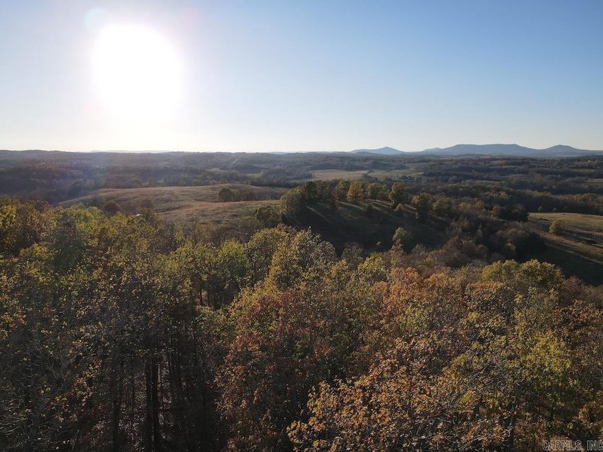 My goodness what a sweet recreational property with phenomenal access and some remarkable Ozarks beauty. This hardwood tract is prime for any hunter or outdoorsman looking for quality land with rolling terrain and mature timber. The well-maintained county gravel road fronts the property for about ¼ mile and provides ample access to the level ridge top that makes up a good portion of the land, and the views to the West are truly spectacular and breathtaking. The surrounding valleys and mountains are an inviting canvas that speak to the heart and soothe the soul. This gem gently rolls from the ridge through some impressive white oak, red oak, black oak, hickory, and other hardwood trees. Intermittently through the 2 main ravines are some super cool rock outcroppings, small overhangs, and a seasonal spring. A recently built trail system will aid in navigation by ATV or UTV all over the property. This trail system spans over one mile! A newer small clearing would be ideal for a food plot to attract the resident wildlife. The region's healthy whitetail deer herd, black bear, turkey, and other game all roam these hills and make this a mecca for any hunter.