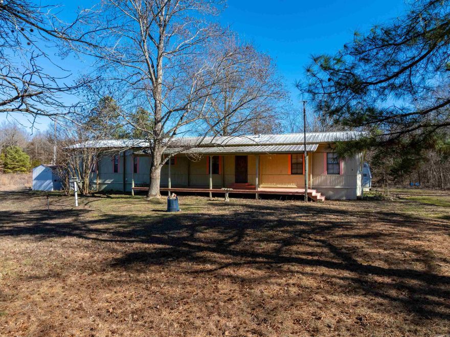 This single-wide mobile home sits on approximately 8 +/- acres just north of Cave City, Arkansas, and only a couple of miles south of Ash Flat along Highway 167. While the property offers convenient highway access, the home is set back off the road, providing a quiet and peaceful setting. The property is located on a beautiful piece of land known locally as Bailey’s Fish Farm, featuring what were once fish ponds that add character and scenic views. These ponds can be enjoyed from both the front and back porches. The sellers have cleaned up and improved the property, creating a relaxing outdoor environment. The mobile home has been updated by the current owners, including a new Coleman furnace. The home is served by a 151 +/- foot-deep well, with county water available at the road. A new pressure tank for the water system will be installed prior to closing. Electric service is provided by North Arkansas Electric Cooperative, with NEXT fiber available at the road. The owned propane tank services heat only. All appliances currently in the home will convey to the new owners. Some roofing repairs have been completed, with portions being newer. With ample acreage, there is room to hunt!