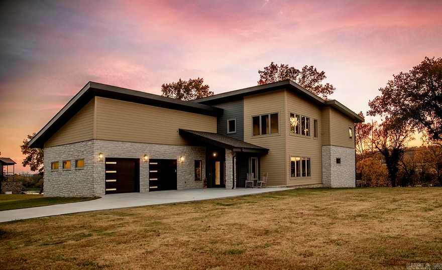 Modern architecture and a backdrop of the White River create extraordinary curb appeal. This 3 bedroom, 3.5 bathroom home features  open concept living, dining and kitchen area which provides a fantastic space for entertaining. Upstairs, you'll find a second living area, 2 bedrooms, 2 full bathrooms, spacious heated and cooled bonus room,  plus office space. Buyers will love the whole home generator, efficient utilities, gas fireplaces on both floors, and access to fiber internet. Additional features include handicap accessible main floor with an elevator for second floor access, heated indoor therapy pool, low maintenance deck, two car garage, oversized laundry/mud room, and city water and city sewer services.