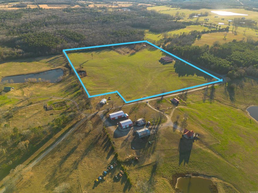 PRIME property overlooking the Ozark Mountains! 32 acres +/- of beautiful hay farm with a huge 130'x80' wood truss hay barn! The concrete is 100'x80' with two 15' overhang sheds on either side. Pipe fence surrounds entire property. Small pond to the side and irrigation present! Would be a beautiful homestead location or a great income property!   Farm across the road is also for sale: see MLS 25047377. Mineral rights do not convey.
