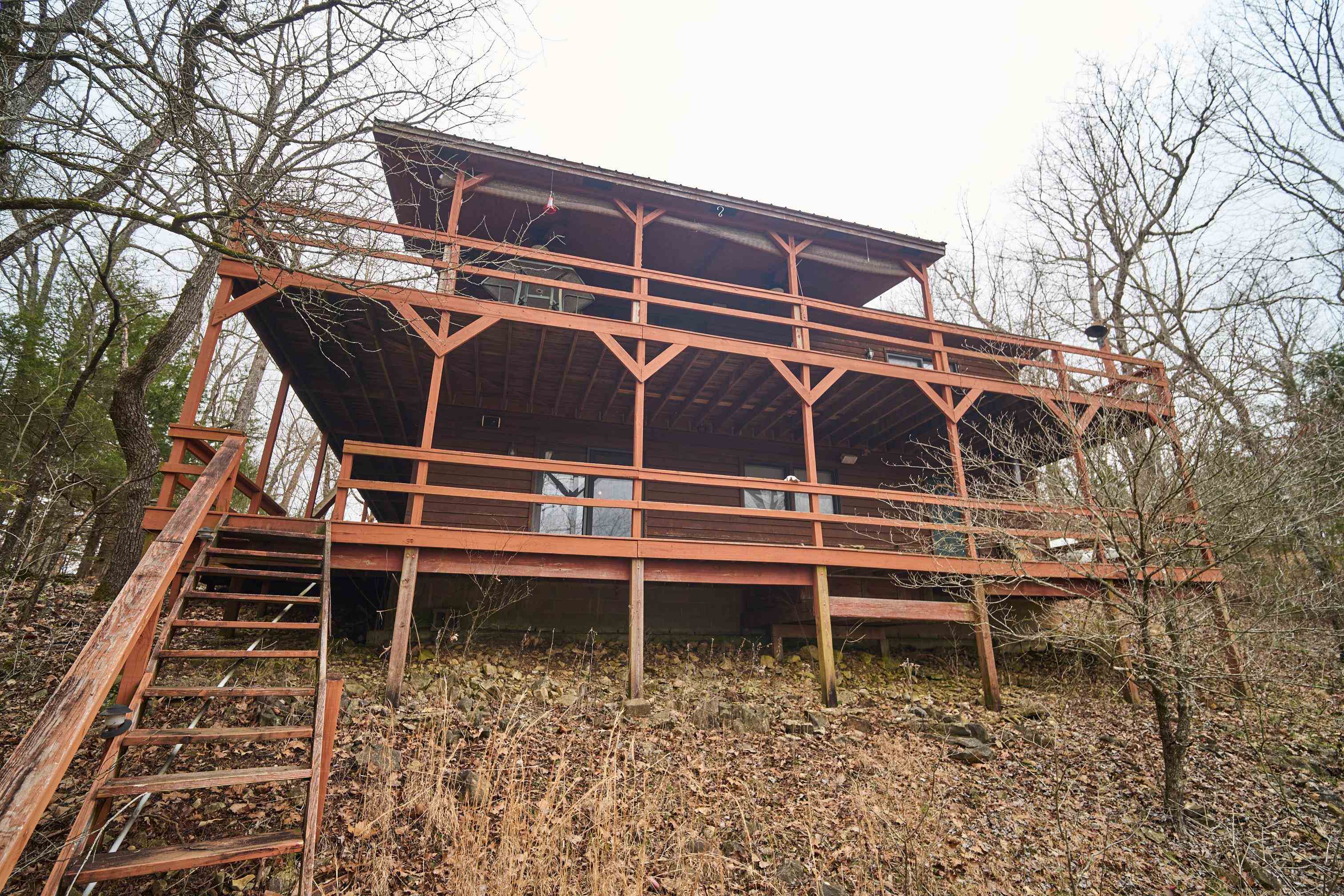 "SPRING RIVER FRONT CABIN- IN TROUT WATER" on 3 acres+/- is located in a gated community-MOVE IN READY! Private and secluded. This 4 bedroom 2 bath river cabin has 2560 sq ft overlooks Spring River with a great vista mountain view. The vaulted living room with fireplace- opens onto the covered deck where one can see forever. The primary suite with bath is on the main level & opens to the covered deck. The generous eat in kitchen is on the main level & a guest bedroom. There is a full finished basement w/another two guest rooms. One of the bedrooms has a large sitting area & wet bar. The sitting area could be used as a game room if desired. There is s another bathroom/spa with a walk-in shower, garden tub and dressing room. This walk-out basement has a heated/cooled storage room for river toys, canoes, kayaks, life jackets, fishing tackle & washer & dryer area. One has good inside and outside entry to the basement. An added feature is the trail of stairs leading down to the river and island. Over half of the island belongs to this property offering a great beach area to play and swim w/easy river access. A private driveway leads to the down to the river for suv and atvs.