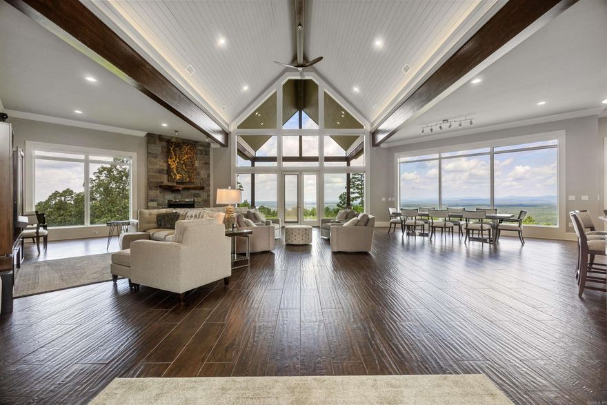 Step into stunning panoramic views the moment you enter—23-foot ceilings and a wall of windows frame Lake Greeson & the surrounding forest. This home offers 57.1 private, wooded acres & comes completely furnished, ready for you to move in & enjoy. The open-concept main level features porcelain tile flooring & combines the kitchen, dining, bar/island, & living areas into one expansive space—perfect for entertaining. The chef’s kitchen boasts quartz countertops, premium Wolf, Sub-Zero, & Bosch appliances,an oversized gas range, built-in ice maker, wine fridge & a reverse osmosis water filtration system. The cozy living area is anchored by a wood-burning fireplace w/ a gas starter, while a second gas fireplace warms the spacious main-level Primary suite w/ luxurious ensuite bath. At the opposite end of the home is a 2nd Primary King bedroom w/ en suite bath & walk-in shower, for a total of 3 kings down & 3 queens up. Upstairs offers three of the bedrooms & an additional full bath—ideal for guests or family. The laundry room is thoughtfully equipped w/ a utility sink & built-in ironing board. Electric blinds in living dining & main bedroom. Manual blinds in all other rooms.