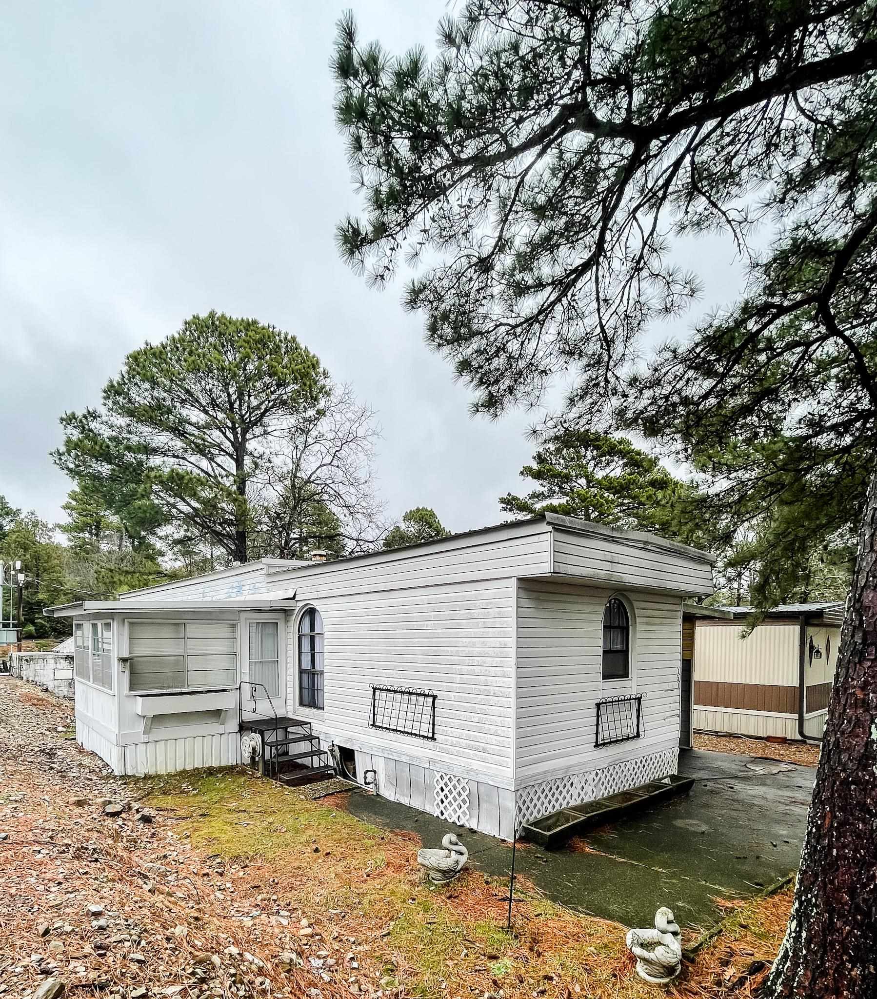 Welcome to Timbercrest, a 55+ community! This home has space to spread out - a 2 bed, 2 bath split floor plan. Sunroom, concrete storm shelter, covered carport with deck. Lots of storage - pantry, spacious closets, built-in cabinets in the dining area, outdoor storage shed. New carpet in the primary bedroom with walk-in closet and walk-in shower. Refrigerator and washer and dryer included! Handicap accessible ramp in the carport.Don't miss this one!