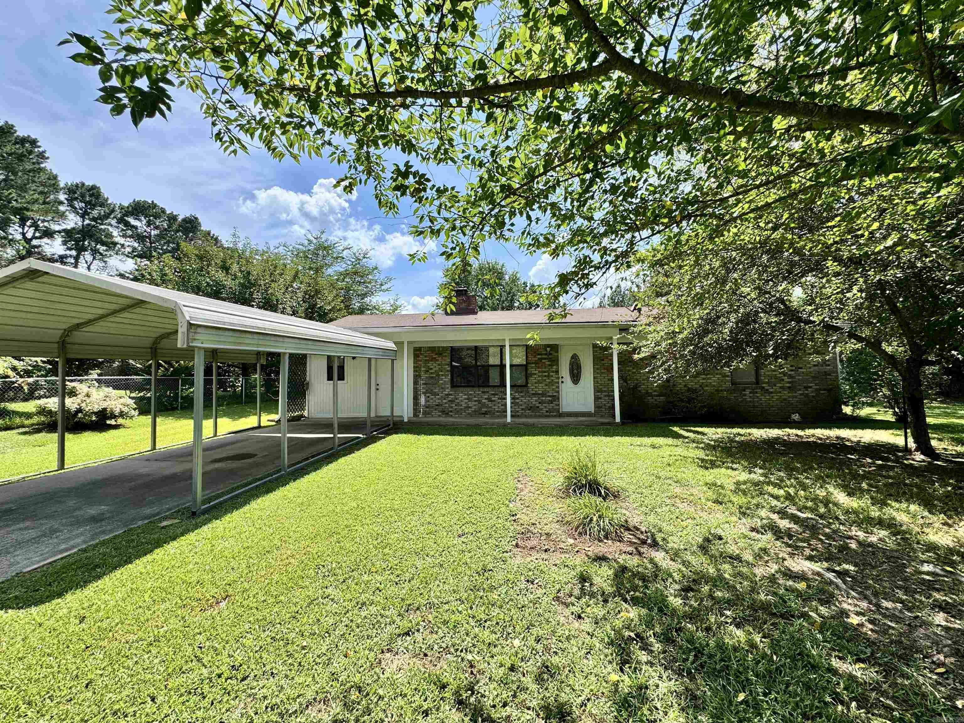 Well maintained home sitting on a half acre lot filled with fruit trees. Completed fenced level yard. Bright and clean interior with a double sided wood burning fireplace. Large living and dining areas. Covered parking with pole barn in back yard and additional storage building. Enclosed carport could easily be a third bedroom. This home is move in ready.