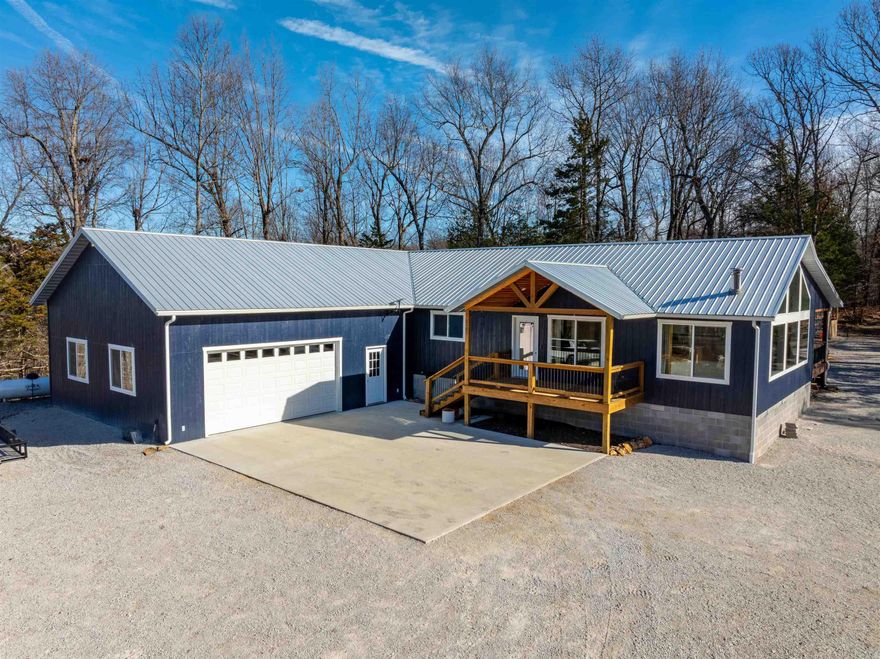 Welcome to Harrison, Arkansas—Ozark living at its finest. Located in Boone County, Harrison is known for its scenic beauty, outdoor recreation, and small-town charm, offering easy access to rivers, hiking, hunting, fishing, and everyday conveniences. This 2024-built home sits on 3.5 +/- established acres with no restrictions and no HOA. Designed to capture the one thing you can’t replace—the view—one entire wall of the home features floor-to-ceiling windows, creating a picture-perfect backdrop from the open-concept living, kitchen, and dining area. Vaulted cathedral ceilings with exposed beams and a cozy corner fireplace add warmth and character. Offering over 3,200 sq ft under roof and approximately 1,930 sq ft heated/cooled, the home features 4 bedrooms and 3 full baths, including two primary suites with jetted tubs.One suite offers a walkout balcony.The kitchen includes a large island with bar seating and opens to a covered back deck, perfect for grilling or enjoying Ozark sunsets. Additional features include central heat and air, metal roof, insulated windows, beautiful flooring, oversized 2-car garage with room for an ATV, large laundry room, walking trails, and fire pit area.